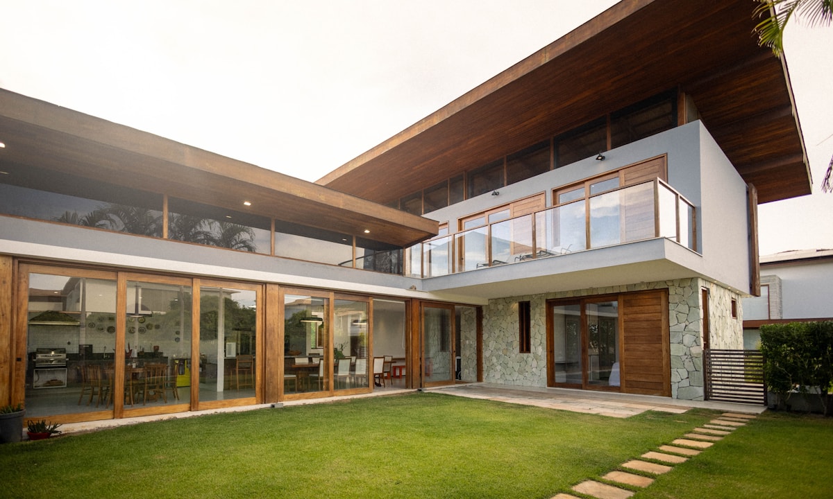Modern home exterior with large windows and lawn
